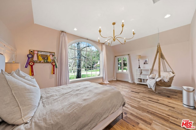 bedroom with wood-type flooring, a notable chandelier, and vaulted ceiling