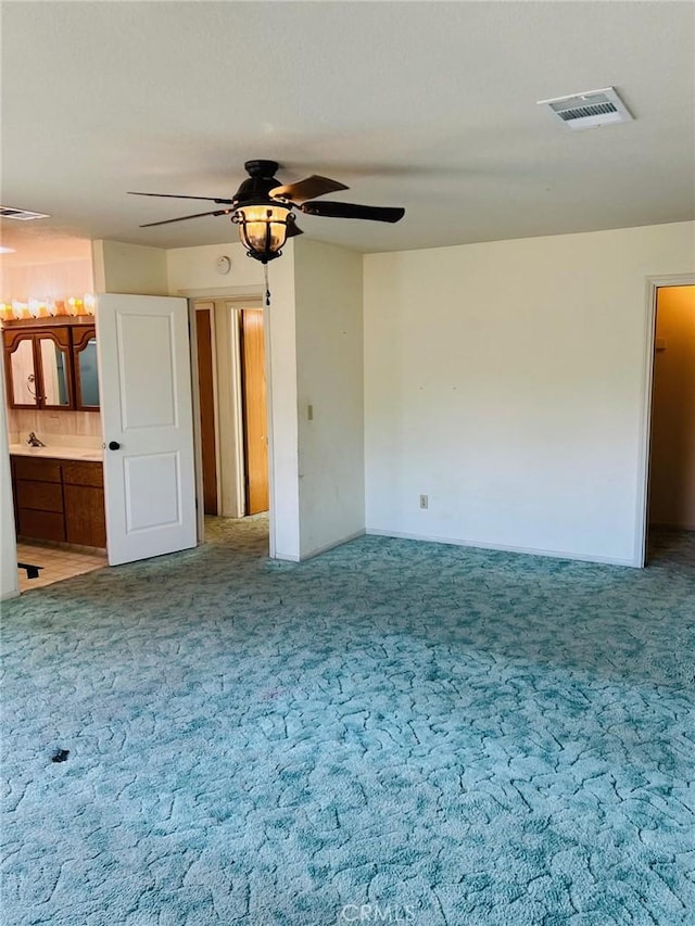 unfurnished bedroom with carpet, connected bathroom, and ceiling fan