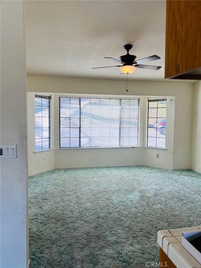 interior space with carpet floors, a textured ceiling, and ceiling fan