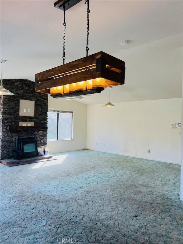 unfurnished living room featuring a stone fireplace and carpet