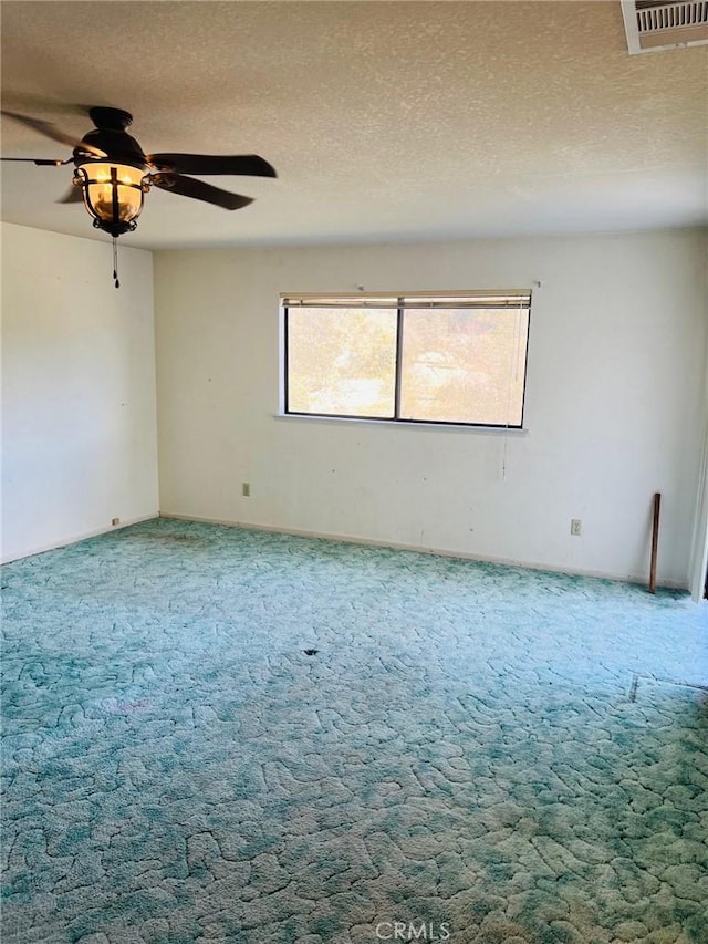 empty room with carpet flooring and a textured ceiling