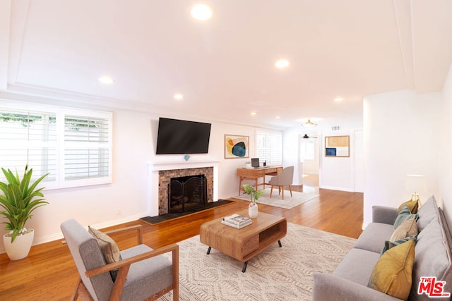 living room with a tile fireplace and light hardwood / wood-style floors