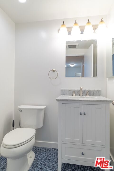 bathroom featuring tile patterned floors, vanity, and toilet