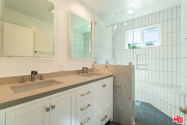 bathroom featuring a tile shower and vanity