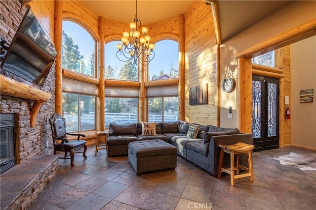 living room with a fireplace, a towering ceiling, and a notable chandelier