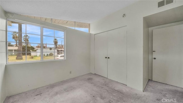 unfurnished bedroom with light colored carpet, vaulted ceiling, and a closet