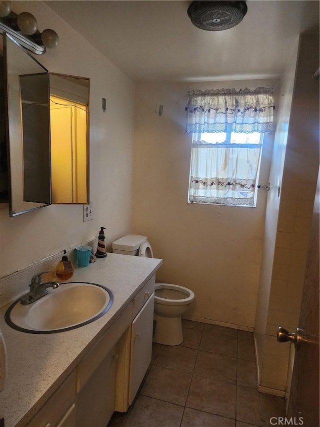 bathroom featuring toilet, vanity, and tile patterned flooring