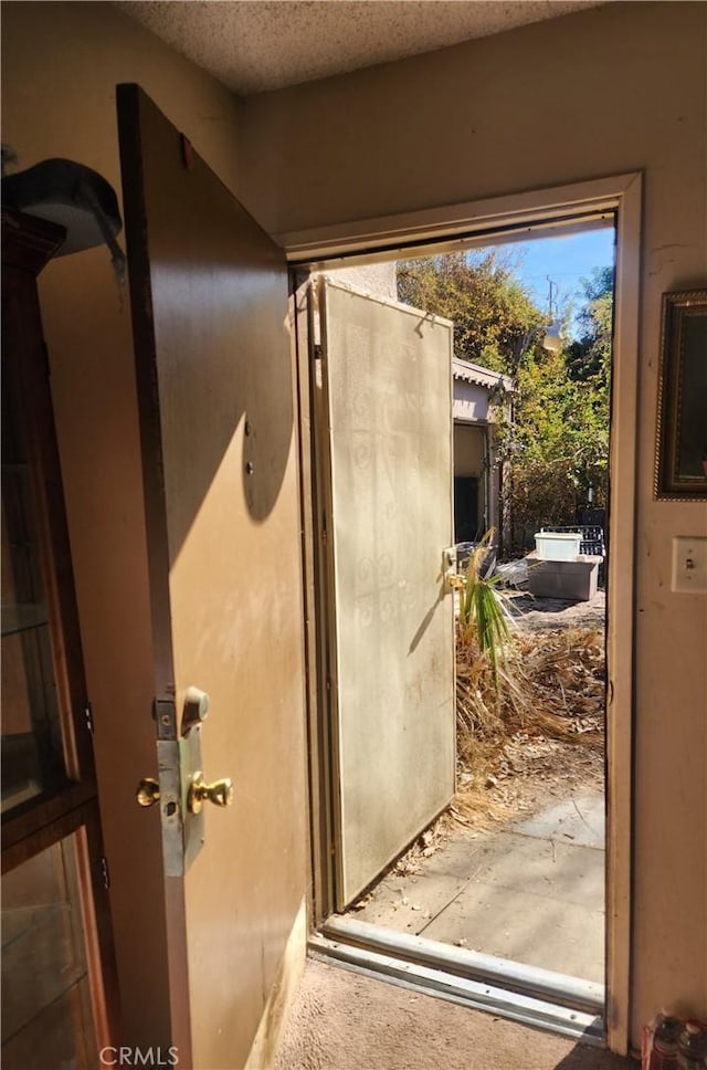 doorway with a textured ceiling