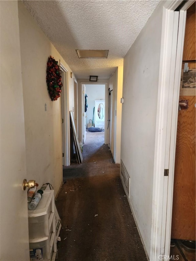 hall featuring a textured ceiling