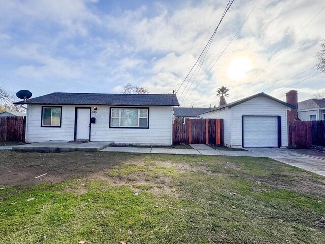 ranch-style home with an outbuilding, a front lawn, and a garage