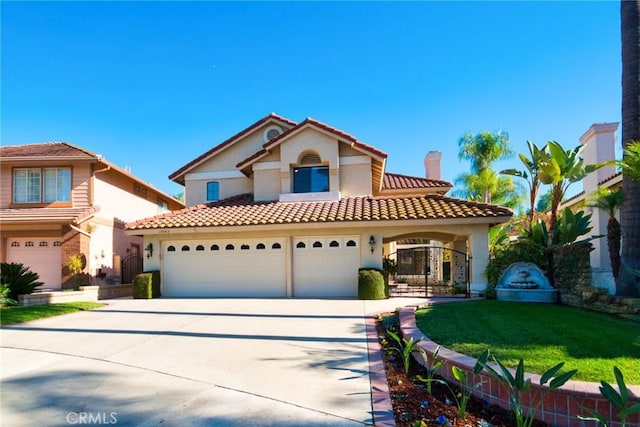 mediterranean / spanish-style house featuring a garage and a front yard