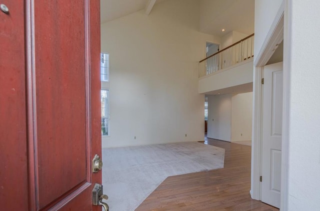 entrance foyer featuring high vaulted ceiling, beam ceiling, and light wood-type flooring