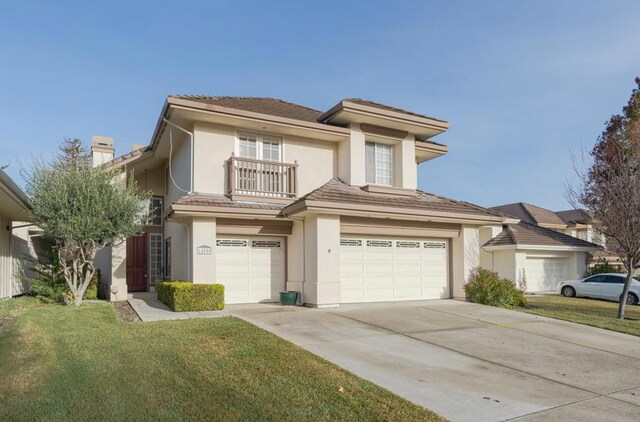 view of front facade with a balcony, a garage, and a front lawn