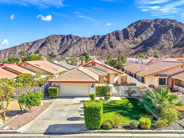 view of front of home featuring a garage, a mountain view, and a front yard