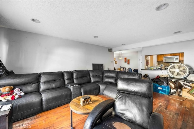 living room with light wood-type flooring and a textured ceiling