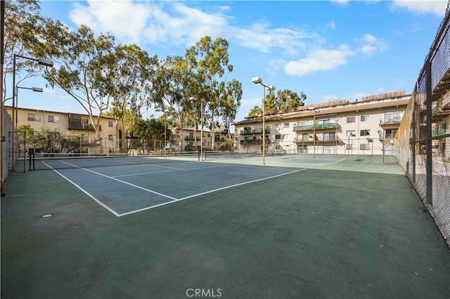 view of tennis court featuring basketball hoop