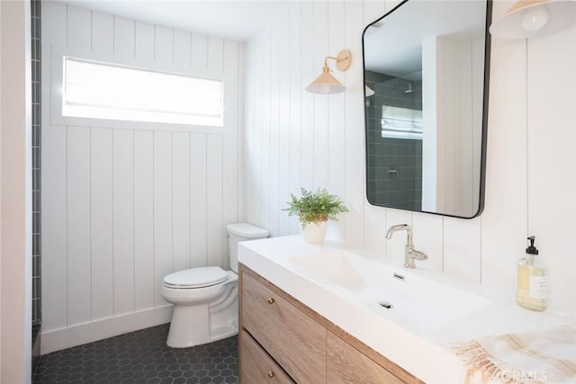 bathroom with toilet, vanity, and tile patterned flooring