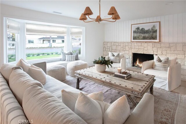 living room with a notable chandelier and a fireplace