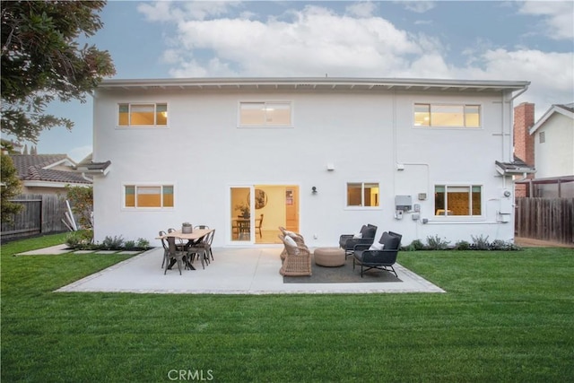 rear view of house with a lawn and a patio area