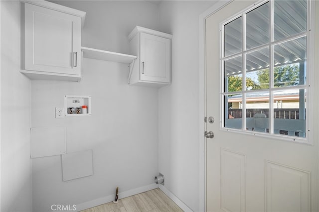 clothes washing area with washer hookup and cabinets