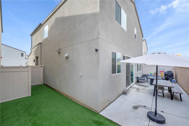 rear view of house featuring a yard and a patio