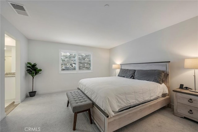 carpeted bedroom featuring ensuite bath