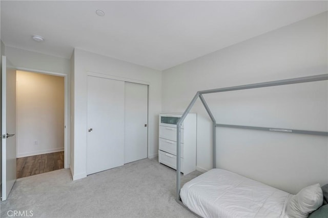 bedroom featuring light carpet and a closet