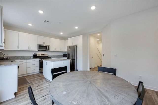 dining area featuring light wood-type flooring and sink