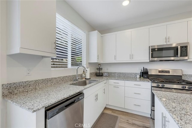 kitchen with sink, stainless steel appliances, and white cabinetry