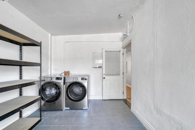 laundry area featuring dark tile patterned floors and washer and dryer