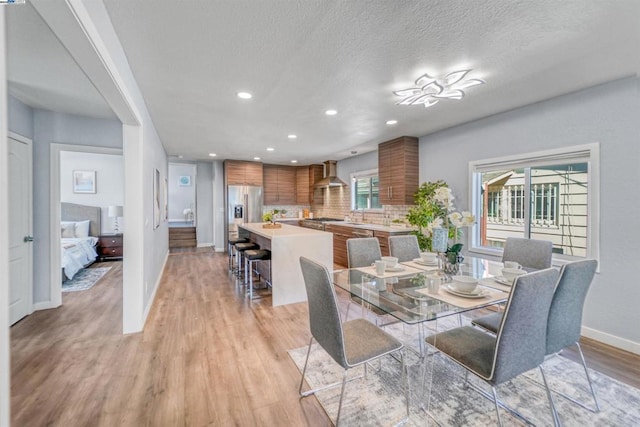 dining area featuring sink, a textured ceiling, and light hardwood / wood-style floors