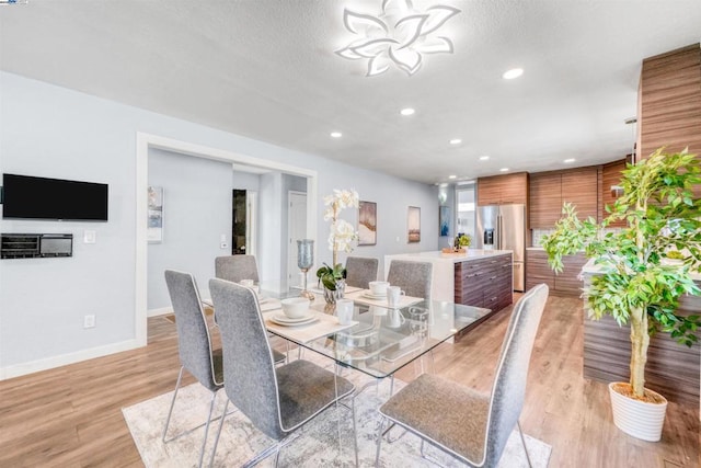 dining area featuring light hardwood / wood-style floors and a textured ceiling