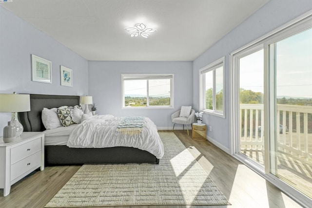 bedroom with access to outside and light wood-type flooring