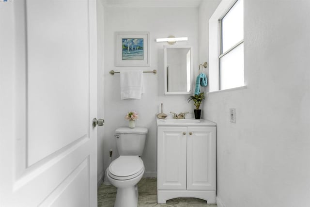 bathroom with a wealth of natural light, toilet, and vanity