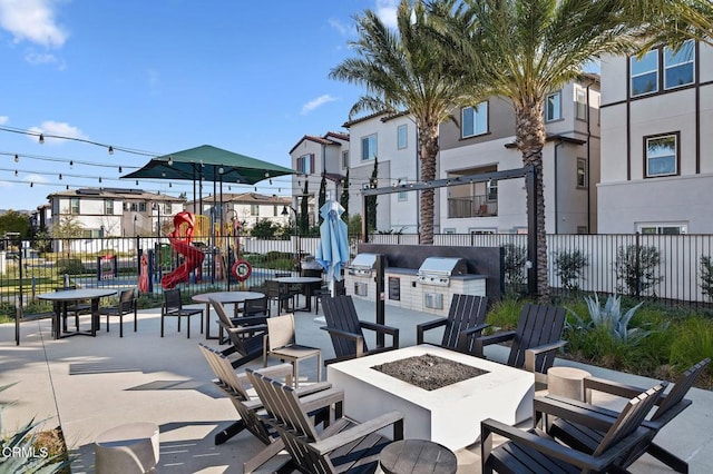 view of patio with a playground, area for grilling, and a fire pit