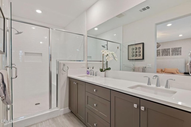 bathroom with a shower with shower door, hardwood / wood-style flooring, and vanity