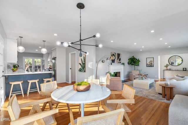 dining room with light hardwood / wood-style floors and a notable chandelier