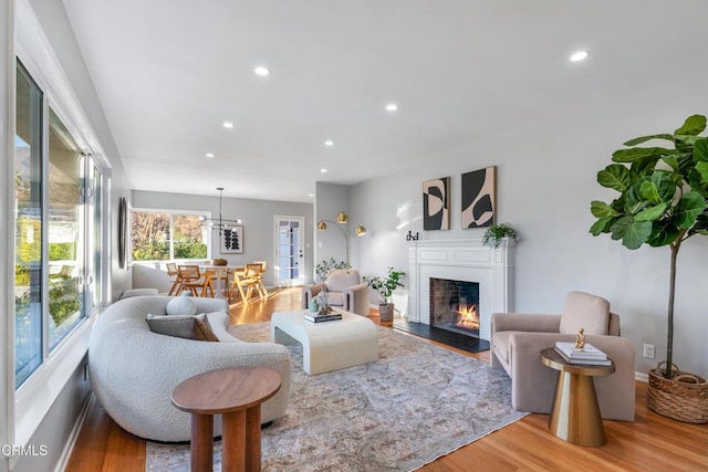 living room with light wood-type flooring and a chandelier