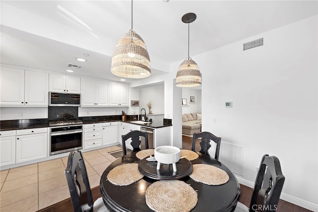 dining room featuring a notable chandelier, light tile patterned flooring, and sink