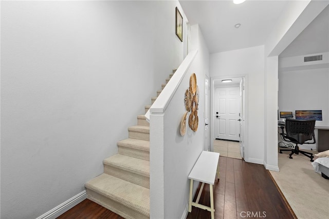 staircase with hardwood / wood-style flooring