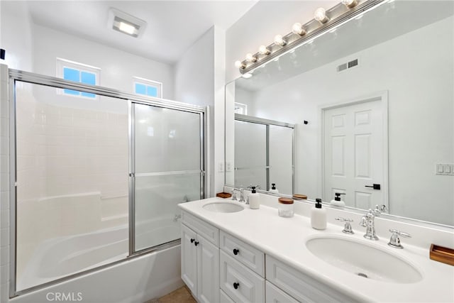 bathroom featuring bath / shower combo with glass door and vanity