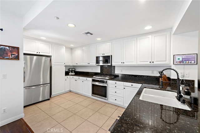 kitchen with sink, white cabinetry, light tile patterned floors, and stainless steel appliances