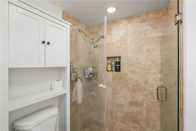 bathroom with toilet and a shower with shower door