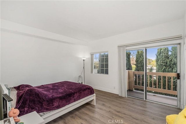 bedroom with access to outside and wood-type flooring