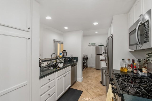 kitchen with sink, light tile patterned floors, stainless steel appliances, and white cabinets