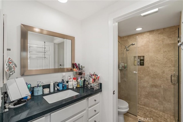 bathroom featuring vanity, an enclosed shower, and toilet