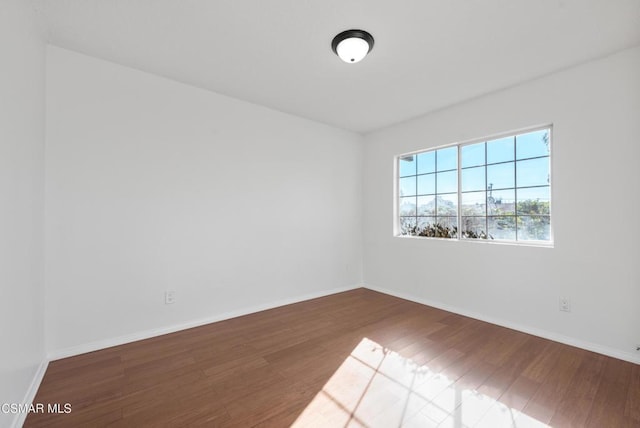 empty room with dark hardwood / wood-style flooring