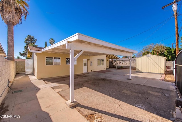 rear view of house featuring a shed and a carport