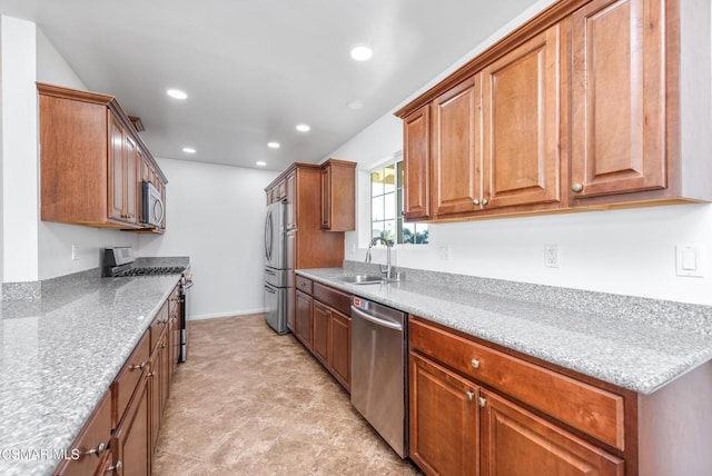 kitchen with light stone countertops, sink, and appliances with stainless steel finishes