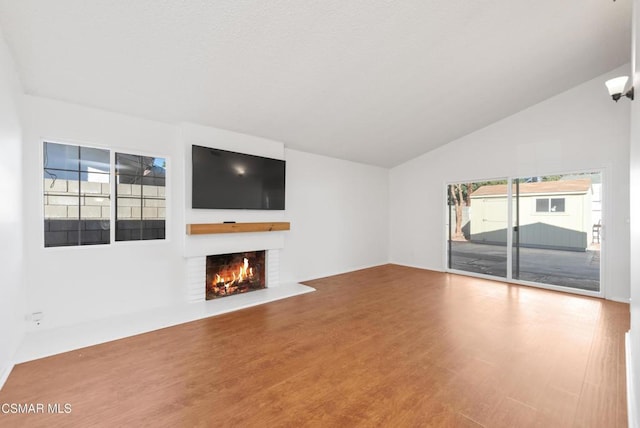 unfurnished living room with wood-type flooring and lofted ceiling